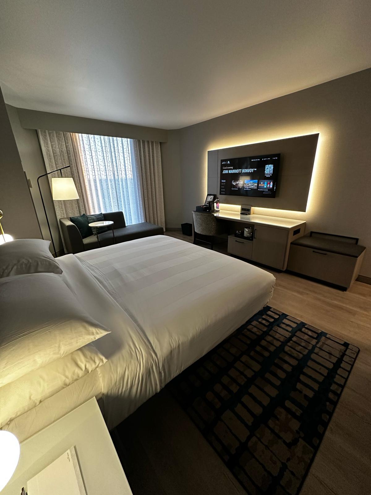 After TrueFlat install — same guestroom with seamless flat ceiling and backlit TV with integrated cove lighting